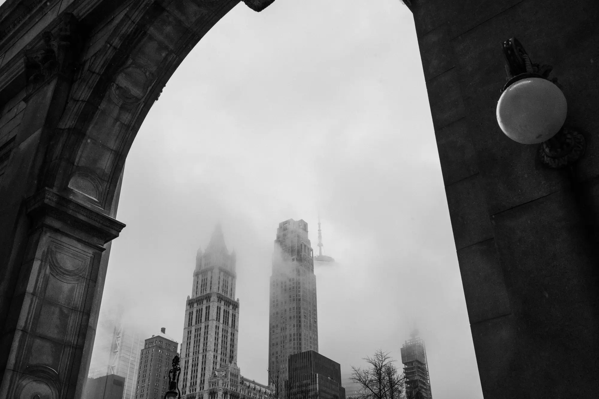 Fog-shrouded tower framed by a stone arch